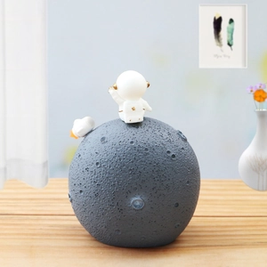 Macro detail of astronaut figurine sitting on moon surface with textured craters