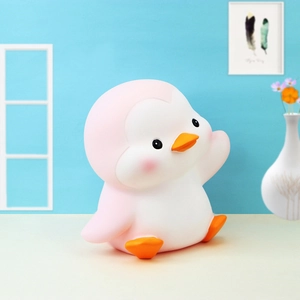 Close-up of pink penguin money box for kids made of soft shatterproof silicone