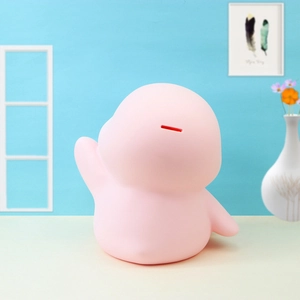 Pink penguin piggy bank with top coin slot in a cozy home setting for kids