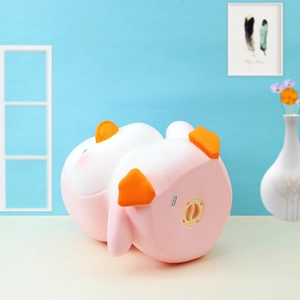 Detail view of the pink penguin piggy bank featuring a bottom twist-lock opening mechanism