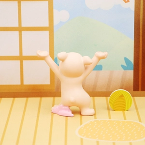 Close-up of a cute pink cat figurine holding arms up for holding pens on a desk