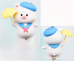 Front and back detail of a cute cartoon bear charm with blue hat and yellow umbrella