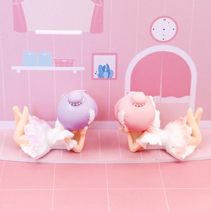Close-up of cute ballet angel figurines in pink and purple with feather texture details