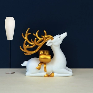 Detail of a modern white reindeer figurine with gold antlers and bow tie decoration