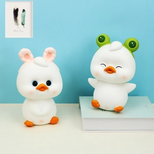 Detail von süßen Enten-Spardosen mit Kaninchen- und Froschhüten als Deko-Geburtstagsgeschenk