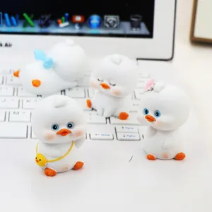 Close-up of four cute resin ducks with different accessories on a laptop keyboard