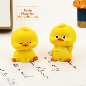 Close-up of hand-painted resin duck figurines with matte finish and blue mini bag details
