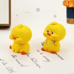 Close-up of two cute resin yellow duck car ornaments in a warm lifestyle desk setting