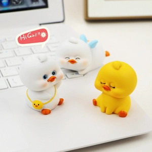 Three cute cartoon duck figurines placed on a laptop keyboard for desktop decor