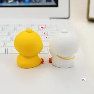 Close-up of cute yellow and white duck desk ornaments on a laptop keyboard
