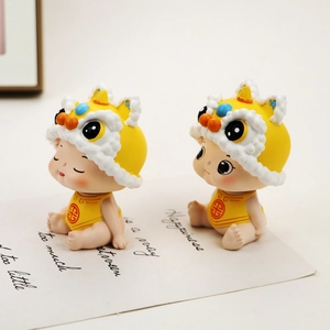 Primer plano de lindas figuras de bebé danza del león chino con gorros amarillos y símbolos