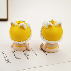 Vista macro de dos lindas figuritas de resina con sombreros amarillos en tarjeta blanca