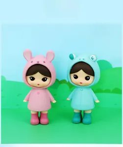 Close-up of cute pink rabbit and blue frog raincoat figurines in high quality PVC material