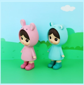 Detail of cute doll figurines in bunny and frog raincoats with matte finish