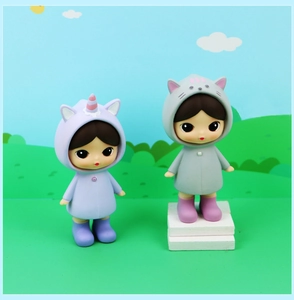 Detail of two cute collectible dolls in unicorn and cat outfits for gift collection