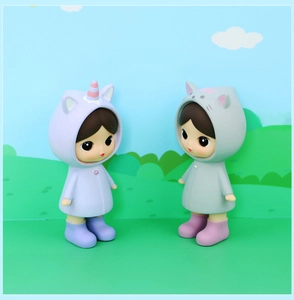 Detail of cute doll figurines in unicorn and cat raincoats with macro resin textures