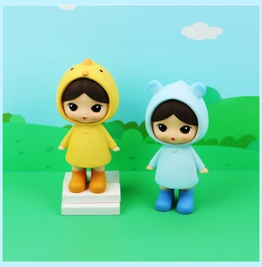 Close-up of cute collectible rain dolls in yellow chick and blue bear raincoats
