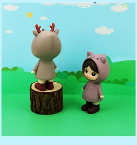 Close-up of cute deer and bear hoodie figurines on wooden stump with cartoon background