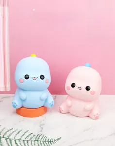 Tirelires dinosaures bleu ciel et rose poudré sur marbre blanc pour chambre d'enfant