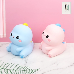 Gros plan d'adorables tirelires dinosaures roses et bleues dans un décor de maison cosy