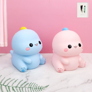Vue détaillée de lampes dinosaures en silicone rose et bleu sur marbre