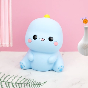 Tirelire dinosaure bleu clair mignonne pour enfants sur une table en marbre blanc
