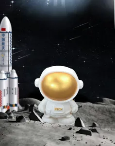 Macro detail of astronaut piggy bank with gold RICH engraving in moon scene
