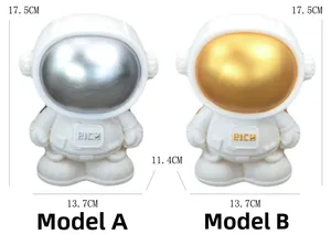 Detailed size comparison of two astronaut money boxes with gold and silver visors