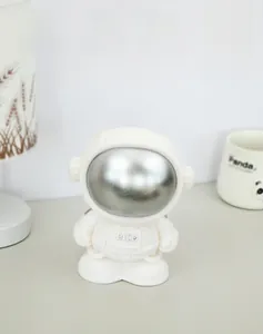 Close-up of white astronaut money box with a metallic silver visor and Rich logo