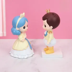 Close-up of Nordic prince and princess figurines on marble base with pink background