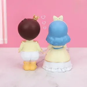 Rear view detail of resin prince and princess figurines showing hair texture and pleats