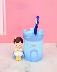 Close-up of blue castle pen holder with a cute cartoon prince figurine for desk storage
