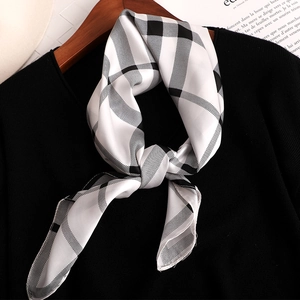 Élégant foulard en soie à carreaux noir et blanc noué sur un cintre de mode