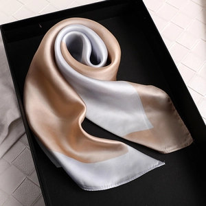 Élégant foulard en satin champagne et argent présenté dans son coffret cadeau noir