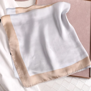 Vue détaillée du foulard carré en soie bleu clair et beige avec une texture satinée