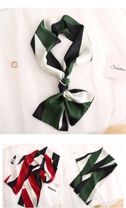 Detail of silk-like striped scarf showing vibrant green, red, and black pattern textures