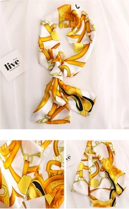 Close-up of ivory silk scarf with equestrian horse motifs and golden chain details