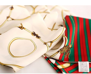 Macro detail of silk scarf featuring chain print and woven care label texture