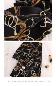 Detail of silk scarf showing elegant equestrian chain pattern and premium texture