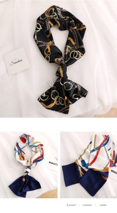 Detail of silk-like neck scarves with chain patterns, belt prints, and elegant tassels