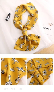 Detail of yellow zebra print silk scarf showing smooth fabric texture and tassel edges