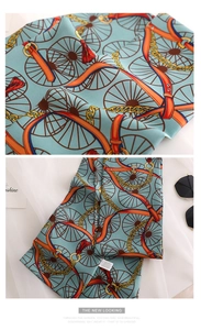 Detail of light blue silk scarf featuring vintage wheel prints and fringe tassels
