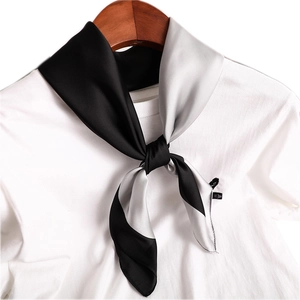 Élégant foulard en satin de soie noir et gris argenté sur un t-shirt blanc et un cintre