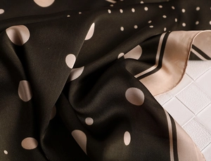 Macro shot of dark brown satin scarf with white polka dots and beige stripe edges