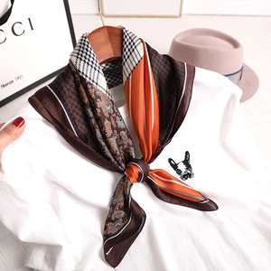 Elegant checkered silk scarf with orange stripes and houndstooth pattern on a white tee