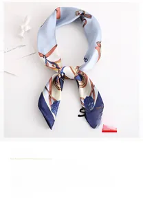 Detailed view of light blue vintage silk scarf featuring gold chain and floral print patterns