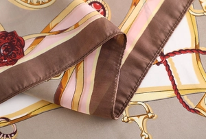 Detailed close-up of retro equestrian print and silk texture on elegant square scarf