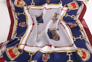 Detailed view of silk-like scarf featuring classic equestrian stirrup and bit print patterns