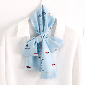 Light blue flamingo print skinny silk scarf with fringe tied on a white shirt
