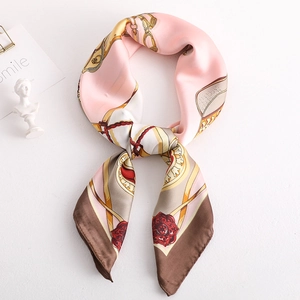 Elegant equestrian silk scarf with pink and gold chain patterns in flat lay styling
